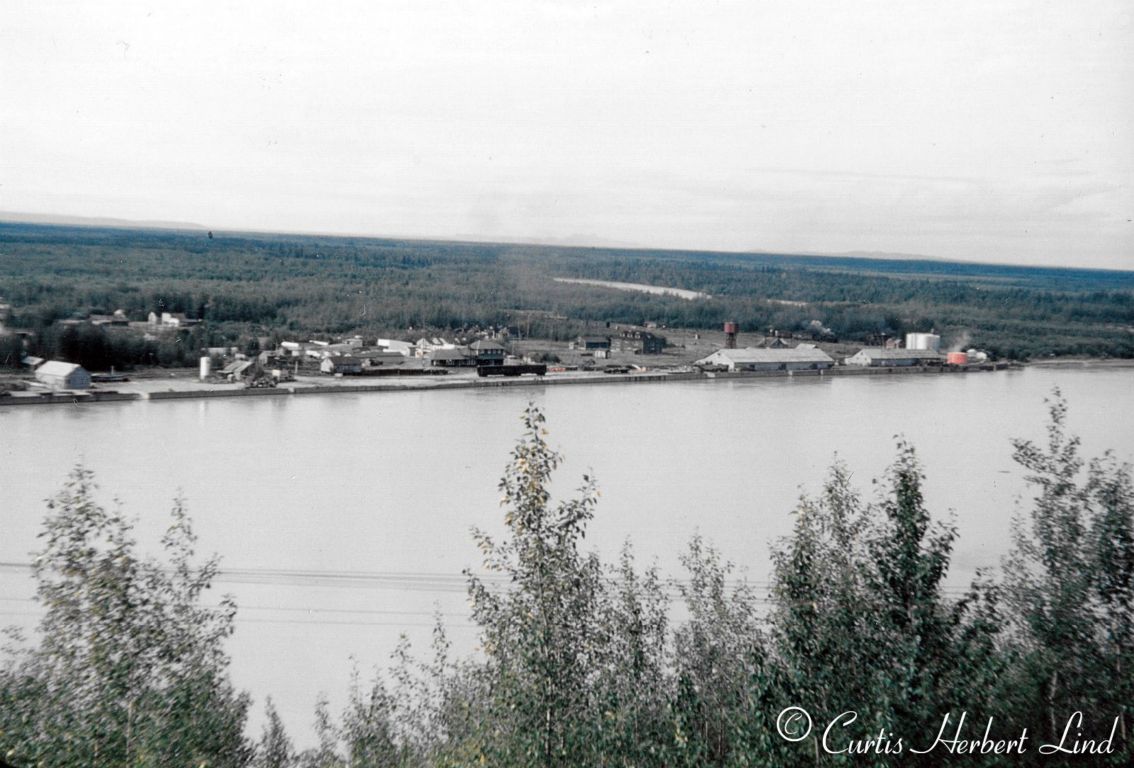 The town of Nenana grew up around the depot in the center of the photo. The warehouses and the fuel tank farm served the River Boats on the Tanana River that connected to the Yukon down stream to the right. The namesake Nenana River comes in from the South and can be seen in the background in this photo taken from the grade at the end of the Mears Memorial bridge that takes the ARR across the river just up steam of the town. There was no highway connection to Nenana in those days.