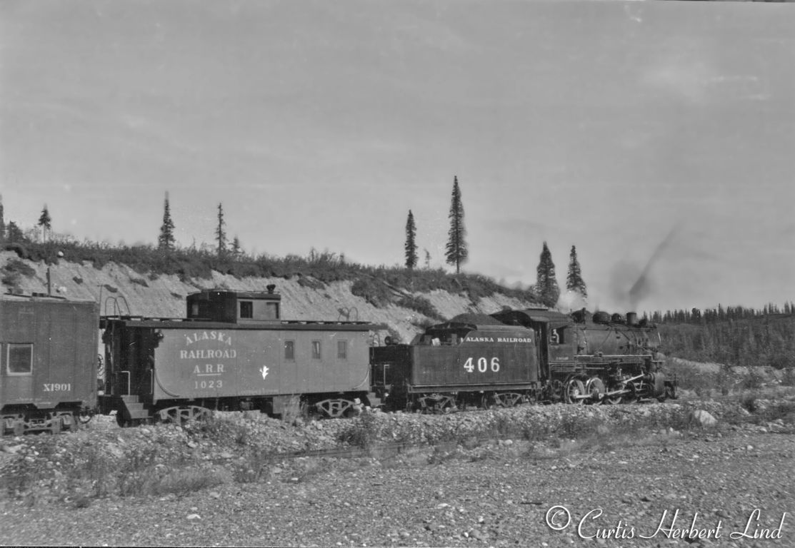 Sure enough, that is 406, a consolidation leading the work extra with an old wooden caboose # 1023 which had been built on a steel frame for snow fleet use. X1901 is one of the Troop Cars received in 1948, still running the Allied Full Cushion trucks. Caboose 1023 one of five all steel cabooses #1022 to 1026 built new in 1946. These were ARR's first all steel cabooses. (The snow fleet cabooses that the ARR built that Pat refers to were # 1021 to 1021).
